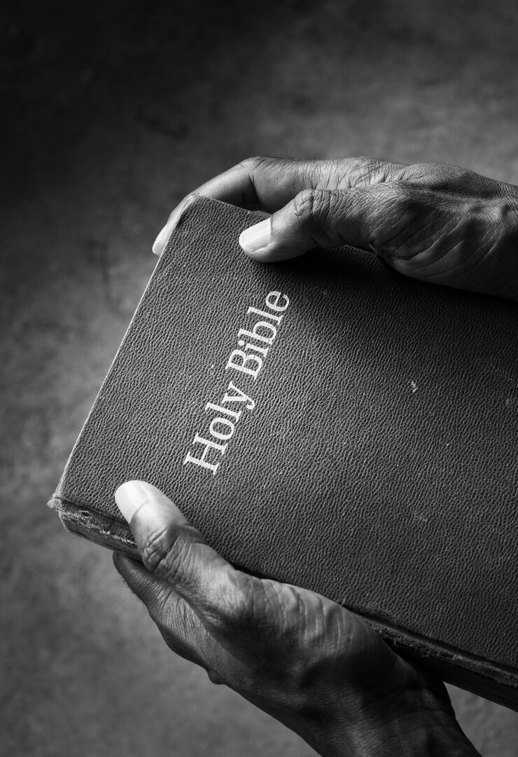 Gros plan d'une vieille Bible sur la main de l'homme