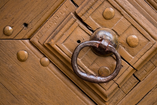 Gros plan de la vieille porte en bois avec décoration en métal.