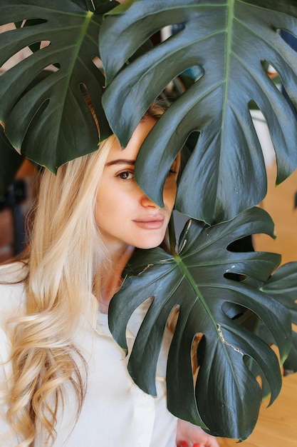 Gros plan sur le visage d'une belle fille partout dans le monde laisse une plante d'intérieur verte