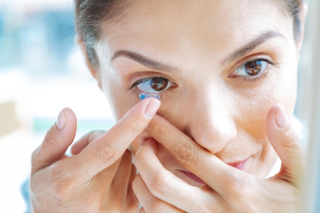 Photo gros plan d'un visage féminin avec des lentilles oculaires mises dessus