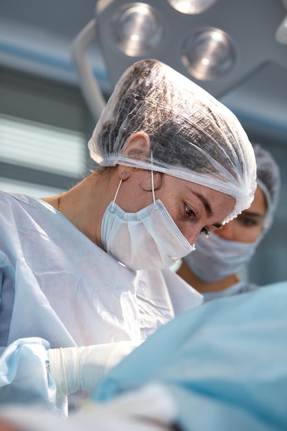 Gros plan sur le visage d'un patient qui subit une blépharoplastie Le chirurgien coupe la paupière et effectue des manipulations à l'aide d'instruments médicaux