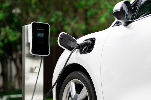 Gros plan sur la voiture EV et le chargeur avec arrière-plan flou pour un concept progressif