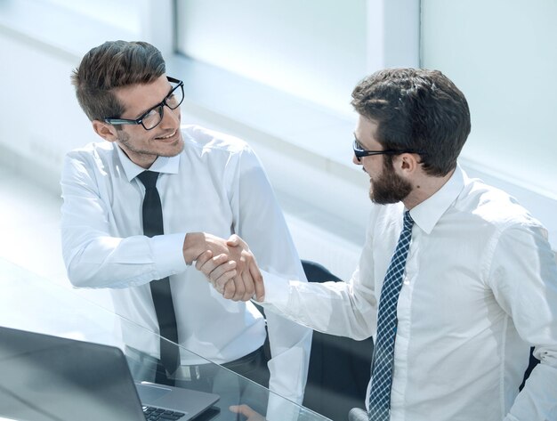 Gros planemployés se serrant la main au bureauPersonnes et technologie