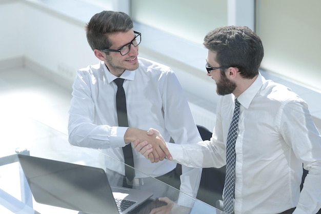 Gros planemployés se serrant la main au bureauPersonnes et technologie