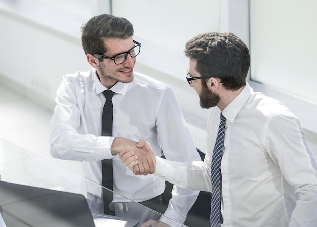 Gros planemployés se serrant la main au bureauPersonnes et technologie