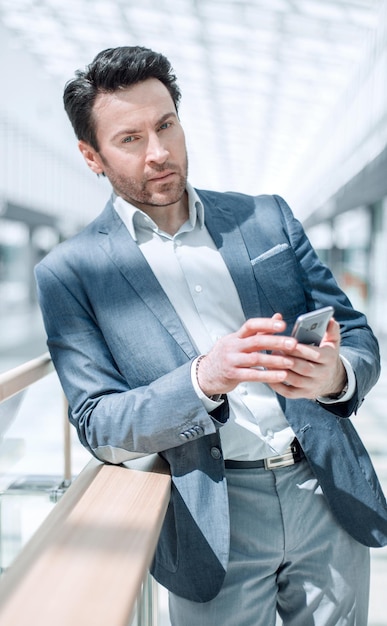 Gros planhomme d'affaires lisant des sms debout dans le bâtiment de l'aéroport