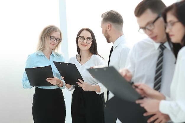 Gros planles employés lisent des documents commerciaux debout dans le bureau