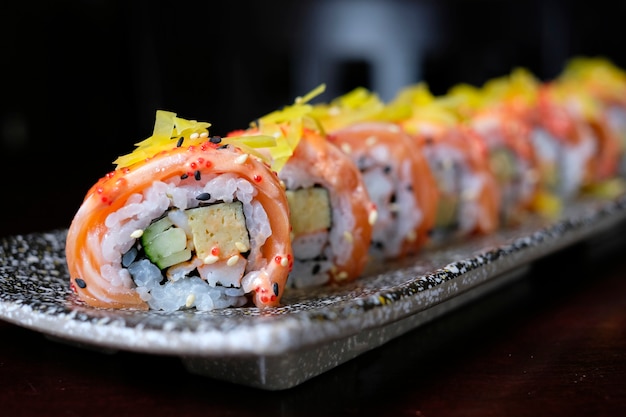 Gros rouleau de sushi au saumon avec sauce épicée - style de cuisine japonaise