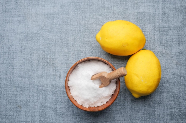 Gros sel dans une cuillère et citron sur fond noir