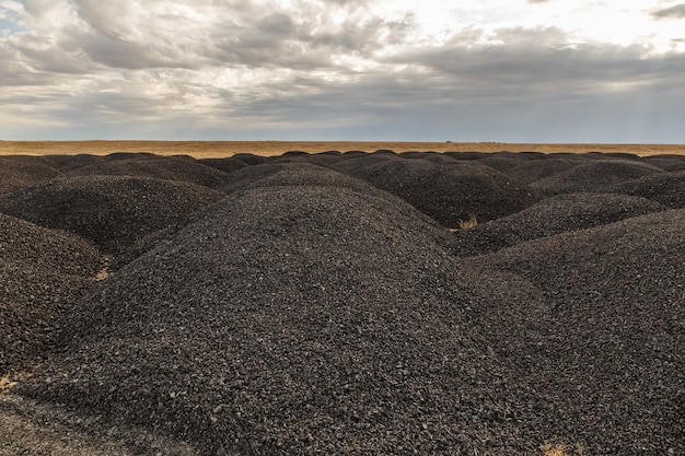 De gros tas de vieux asphalte dans la steppe après la réparation des routes kazakhstan