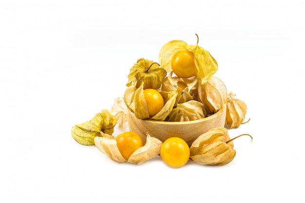 Groseille à maquereau mettre dans un bol en bois physalis isolé sur fond blanc.