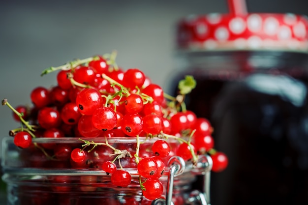 Groseille mûre et son jus de cassis sur une table en bois.