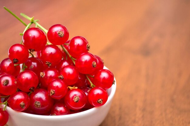 Groseille rouge dans l'assiette sur la table