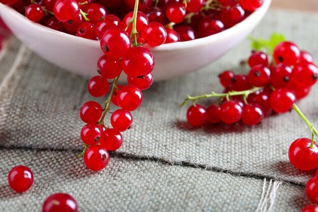 Groseilles rouges fraîches dans un bol sur la table en gros plan