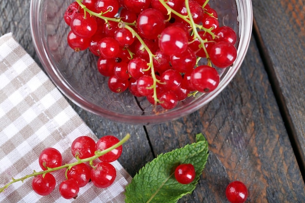 Groseilles rouges fraîches dans un bol sur la table se bouchent