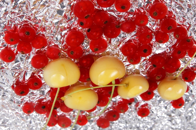 Groseilles rouges juteuses sucrées et cerises jaunes sur fond d'aluminium Vue de dessus Concept de cuisine végétarienne