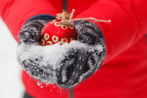 grosse boule de Noël rouge en mains