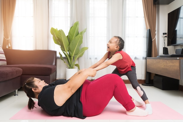 Grosse femme asiatique avec petite fille exerçant à la maison, concept d'idée de sport et de loisirs.