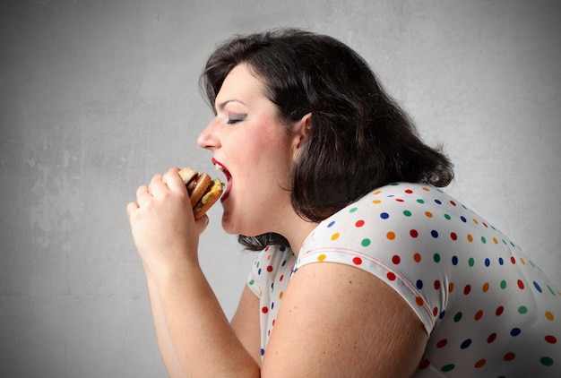 Grosse femme mangeant un hamburger