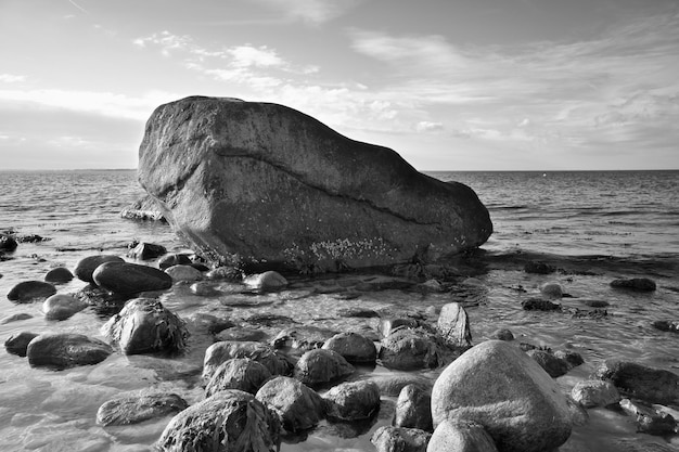 Grosse pierre en noir et blanc prise dans l'eau sur la plage dans la mer danoise