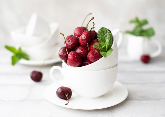 grosses cerises fraîches dans une tasse blanche