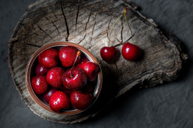 De grosses cerises humides ou des baies de cerises sur un bois foncé