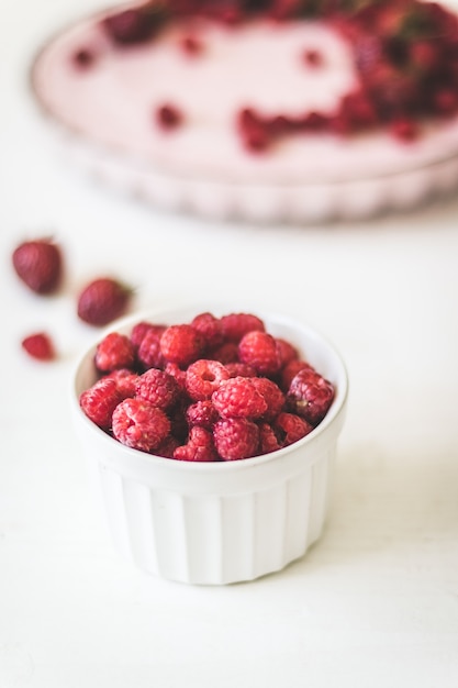 Grosses framboises fraîches dans un masque blanc et une tarte