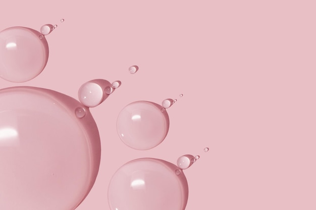 Grosses gouttes de gel d'eau liquide sérum cosmétique sur fond rose