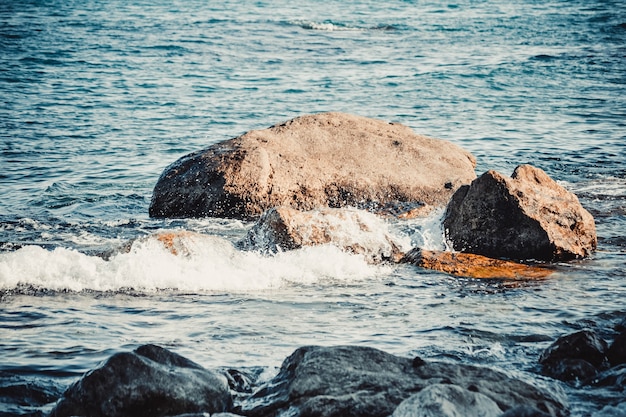 Grosses pierres sur la mer de plage un jour ensoleillé, filtre