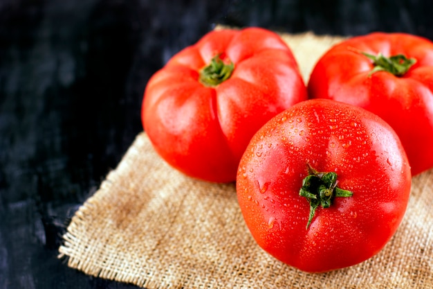 Grosses tomates roses avec des gouttelettes d'eau