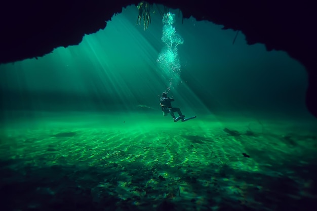 grotte du monde sous-marin du cénote du yucatan, paysage sombre de stalactites souterraines, plongeur