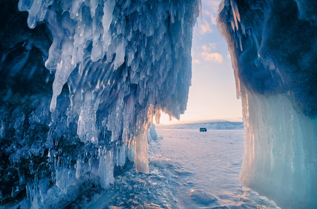 Grotte de glace avec des glaçons dans le lac Baïkal au coucher du soleil Paysage hivernal du lac Baïkal en Russie.