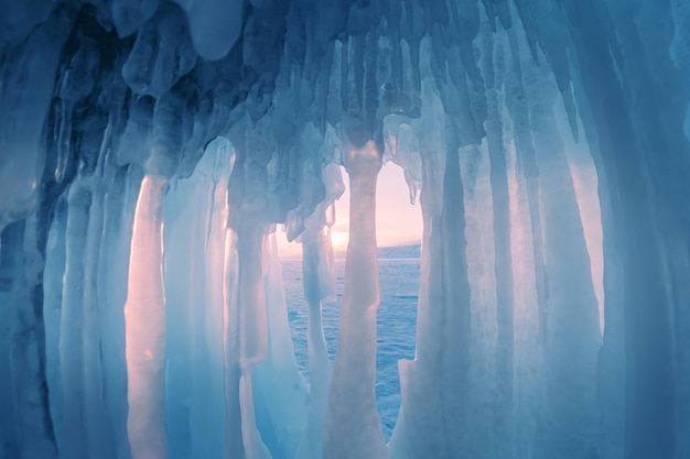 Grotte de glace avec des glaçons sur le lac Baïkal au coucher du soleil