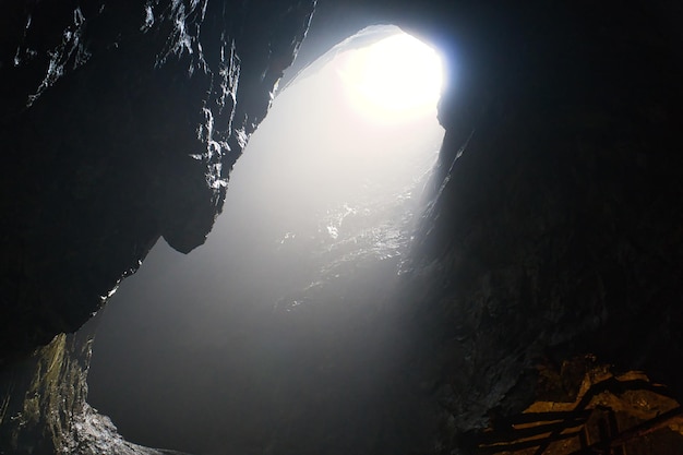 Grotte rocheuse avec trou à travers lequel la lumière brille Underworlds en Suède Mystical