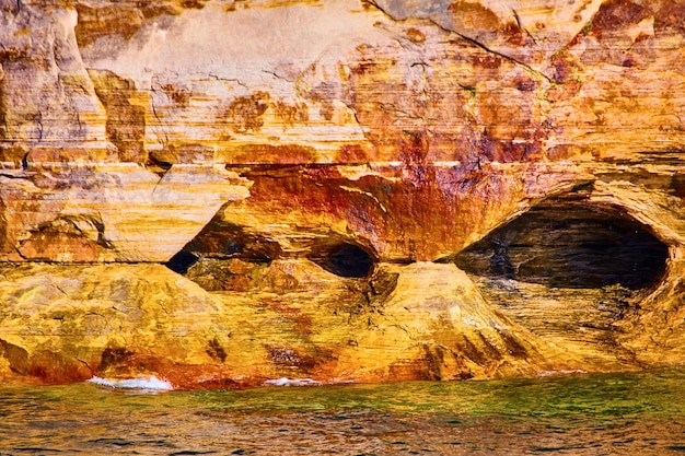 Grottes et cavernes creuses à l'intérieur des rochers illustrés et de l'eau rouillée inquiétante