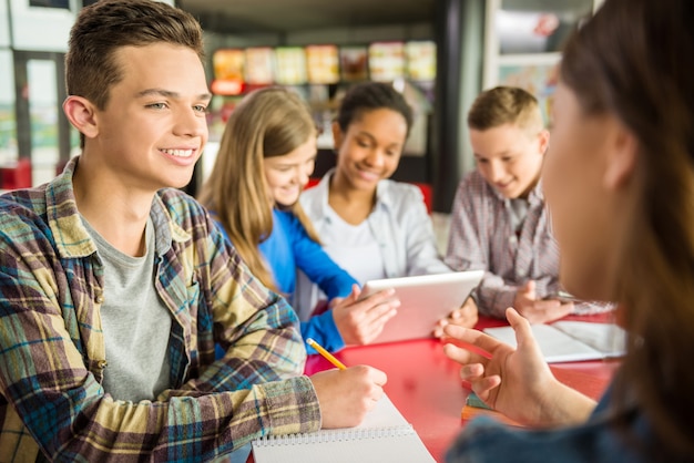 Un groupe d'adolescents assis dans un café et parlant.