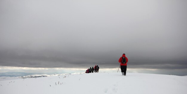 Groupe d'alpinistes marchant dans les montagnes couvertes de neigexAxA