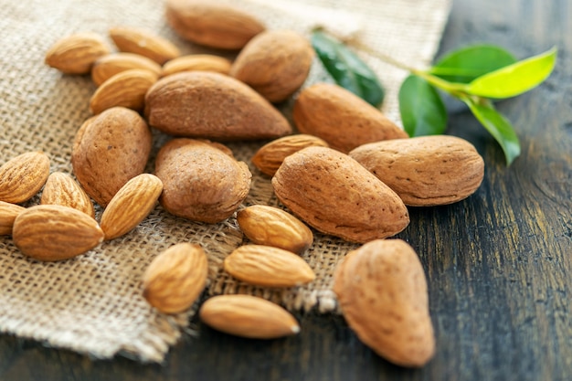 Groupe d'amandes pelées et non pelées sur le fond naturel en bois