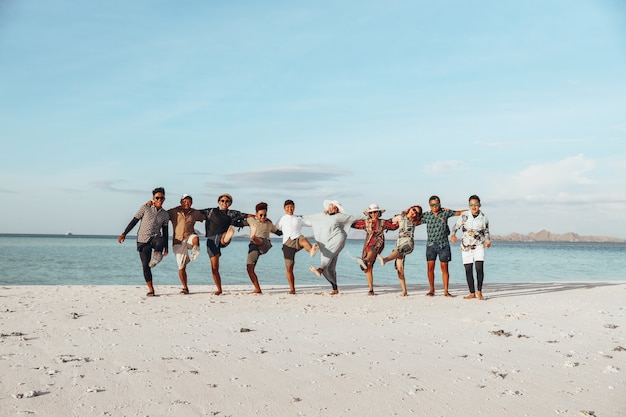 Groupe d'amis asiatiques heureux profitant de vacances avec s'embrasser et danser sur la plage