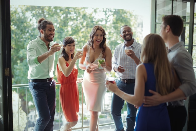 Groupe d'amis ayant un cocktail tout en interagissant