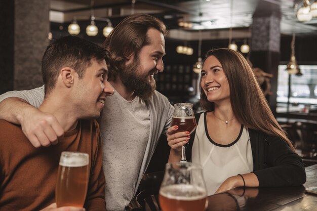 Groupe d'amis célébrant au pub, buvant de la bière ensemble