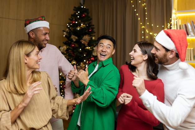 Groupe d'amis célèbrent la fête du nouvel an à la maison dansant ensemble la veille de noël s'amusant maison nouvelle