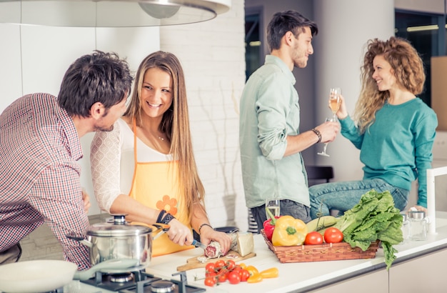 Groupe d'amis cuisinant à la maison pour dîner ensemble