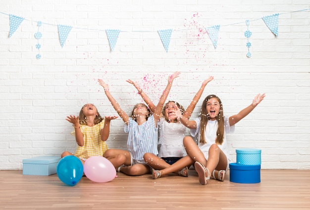 Groupe d&#39;amis dans une fête d&#39;anniversaire jouant avec des confettis