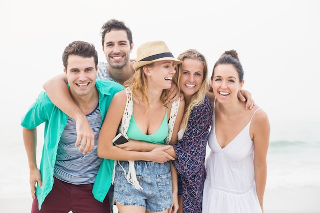 Groupe d'amis debout ensemble sur la plage