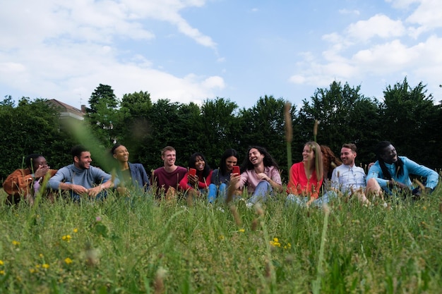 Groupe d'amis de différentes cultures ayant un pique-nique dans le parc à l'extérieur