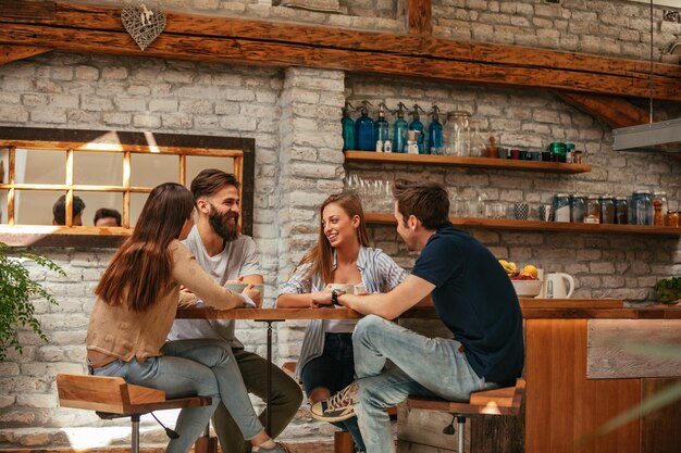 Groupe d'amis discutant et buvant du café à la maison