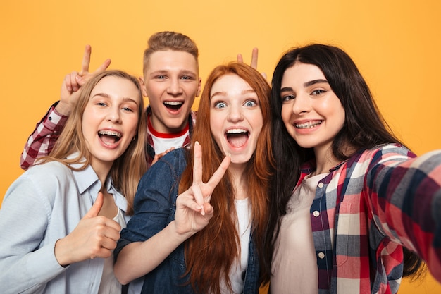 Groupe d'amis de l'école souriant prenant un selfie