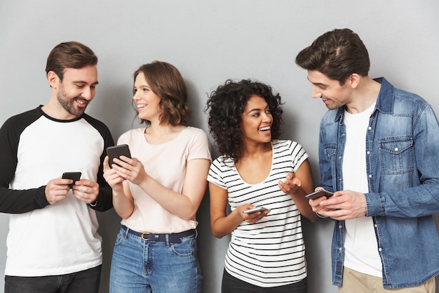 Photo groupe d'amis émotionnels utilisant des téléphones mobiles en conversation.