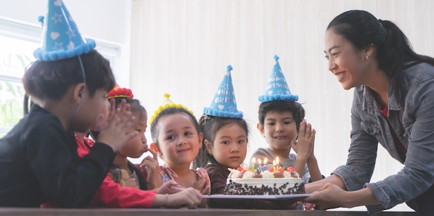 Groupe D'amis D'enfant Attend Pour Souffler Le Gâteau D'anniversaire